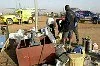 fotografie frank uijlenbroek©2003 frank uijlenbroek<br>040112 Bobo Dioulasso Burkino Fasso<br>Huttenrallyteam Dakar rally<br>foto: Bewoners van Bobo Dioulasso speuren naar bruikbare onderdelen als de rijders vertrekken.